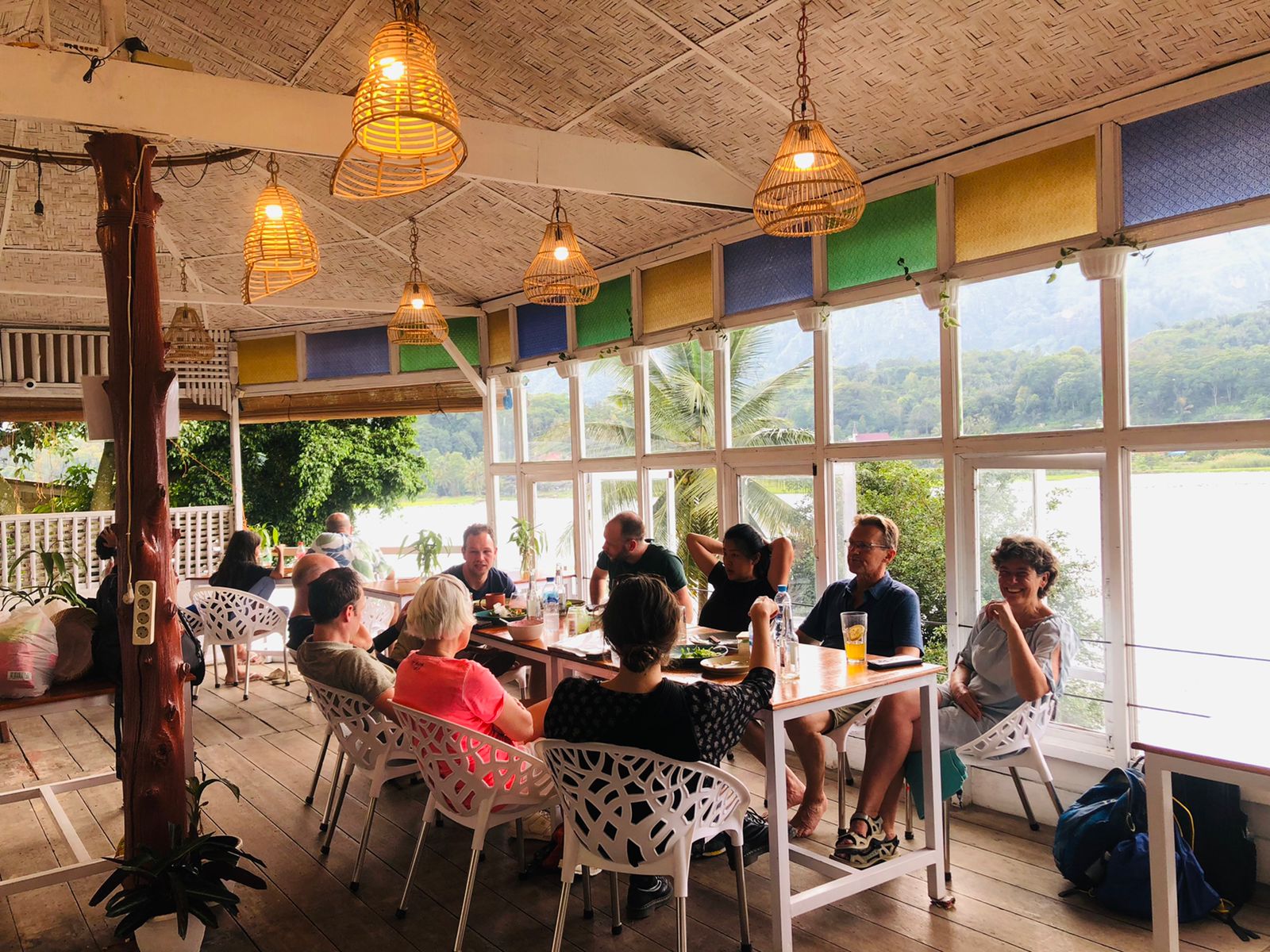 Guests sharing a meal on the lakeside terrace at Hub Tata