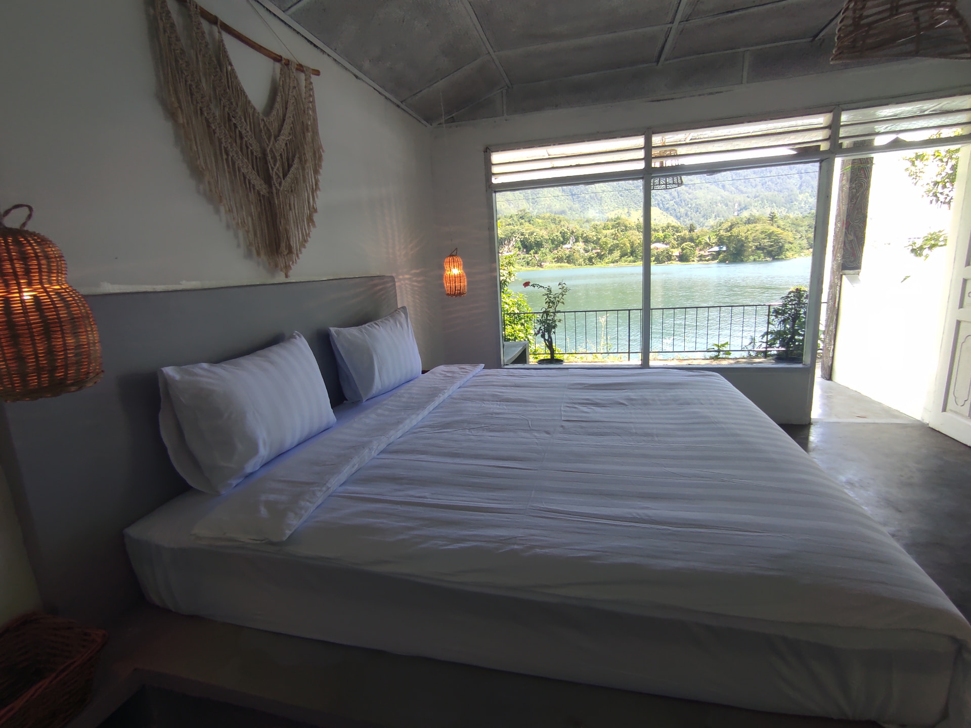 Double Room with Lakeview — double bed facing large windows over Lake Toba