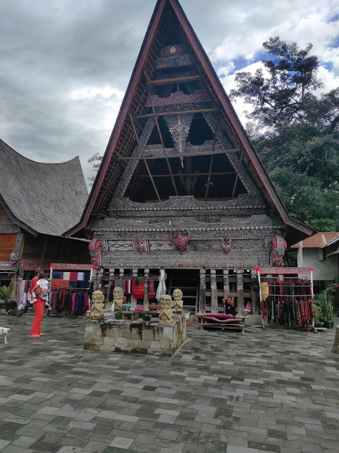Carved traditional Batak house with ulos textiles on display at Kampung Ulos