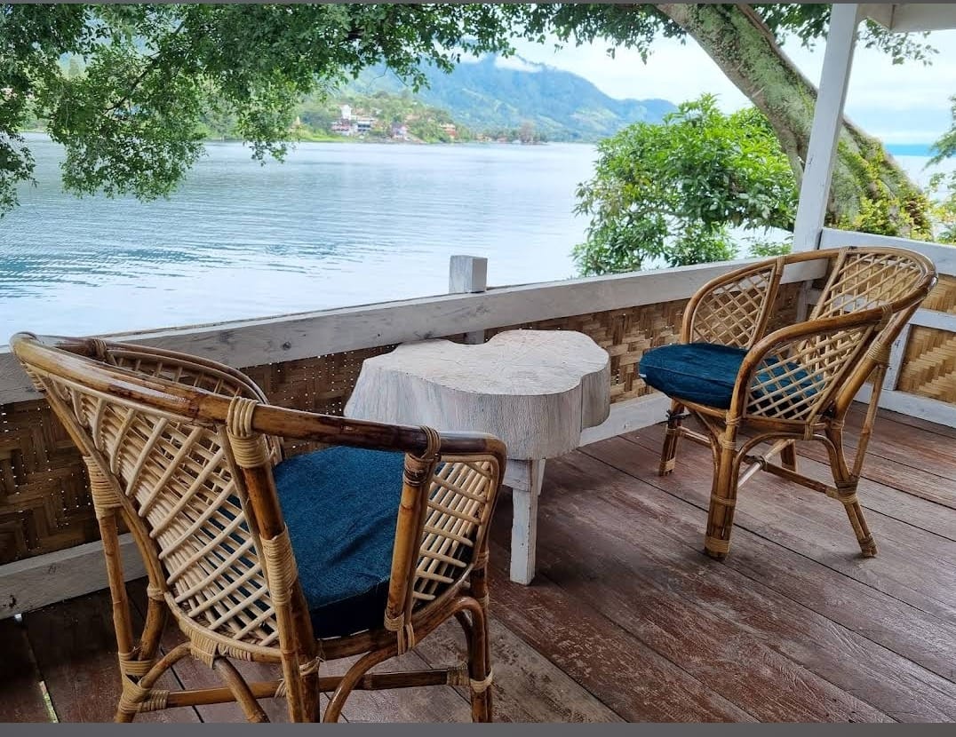 Balcony of the bamboo house with rattan chairs overlooking Lake Toba