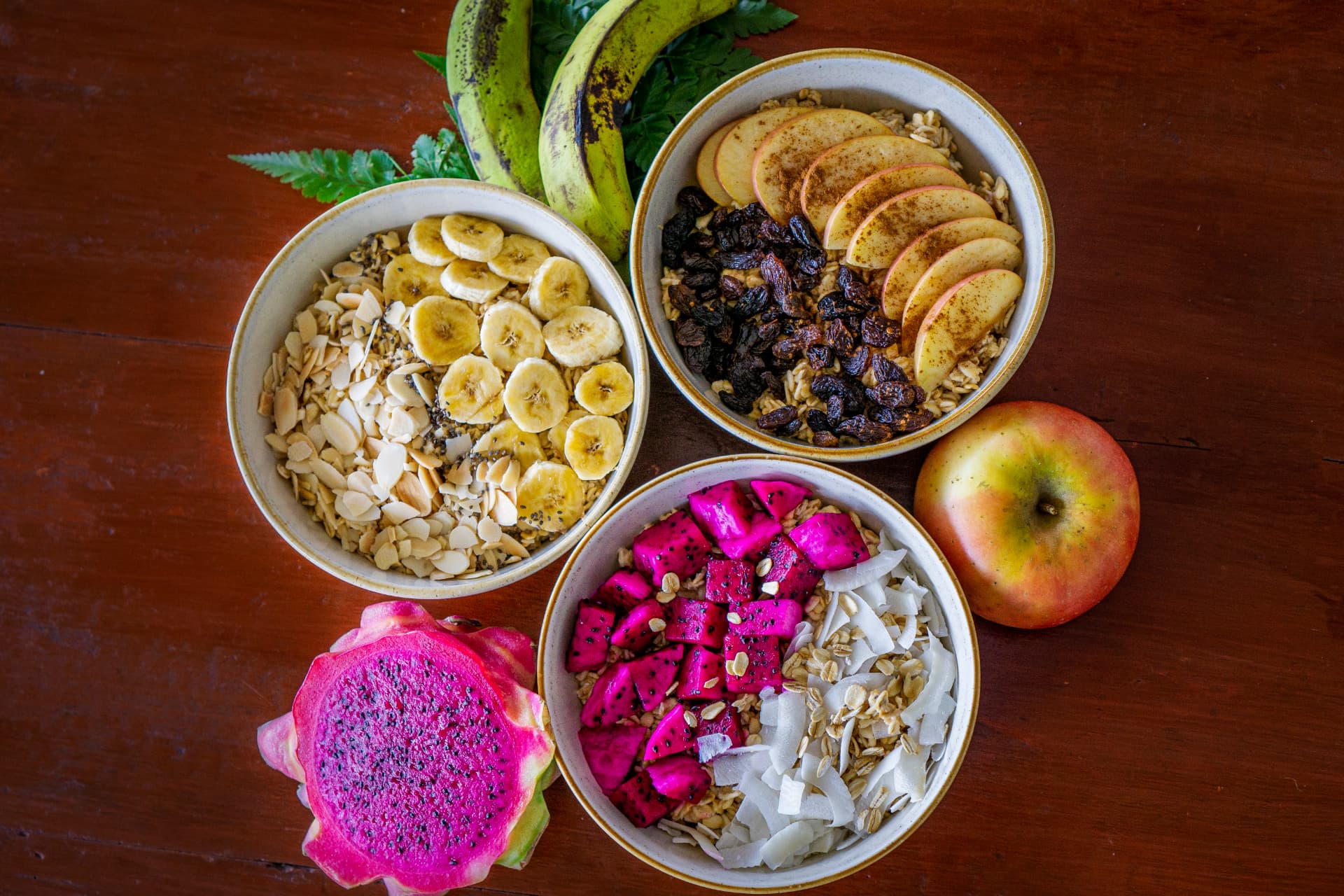 Three overnight oats bowls with banana, apple-raisin and dragon fruit